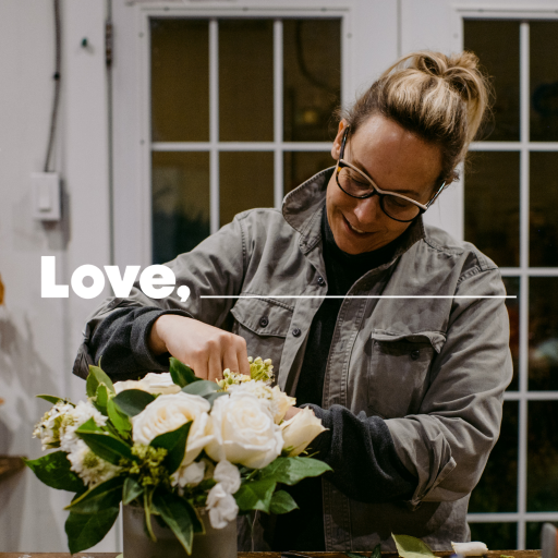 Woman in grey shirt arranging white flowers